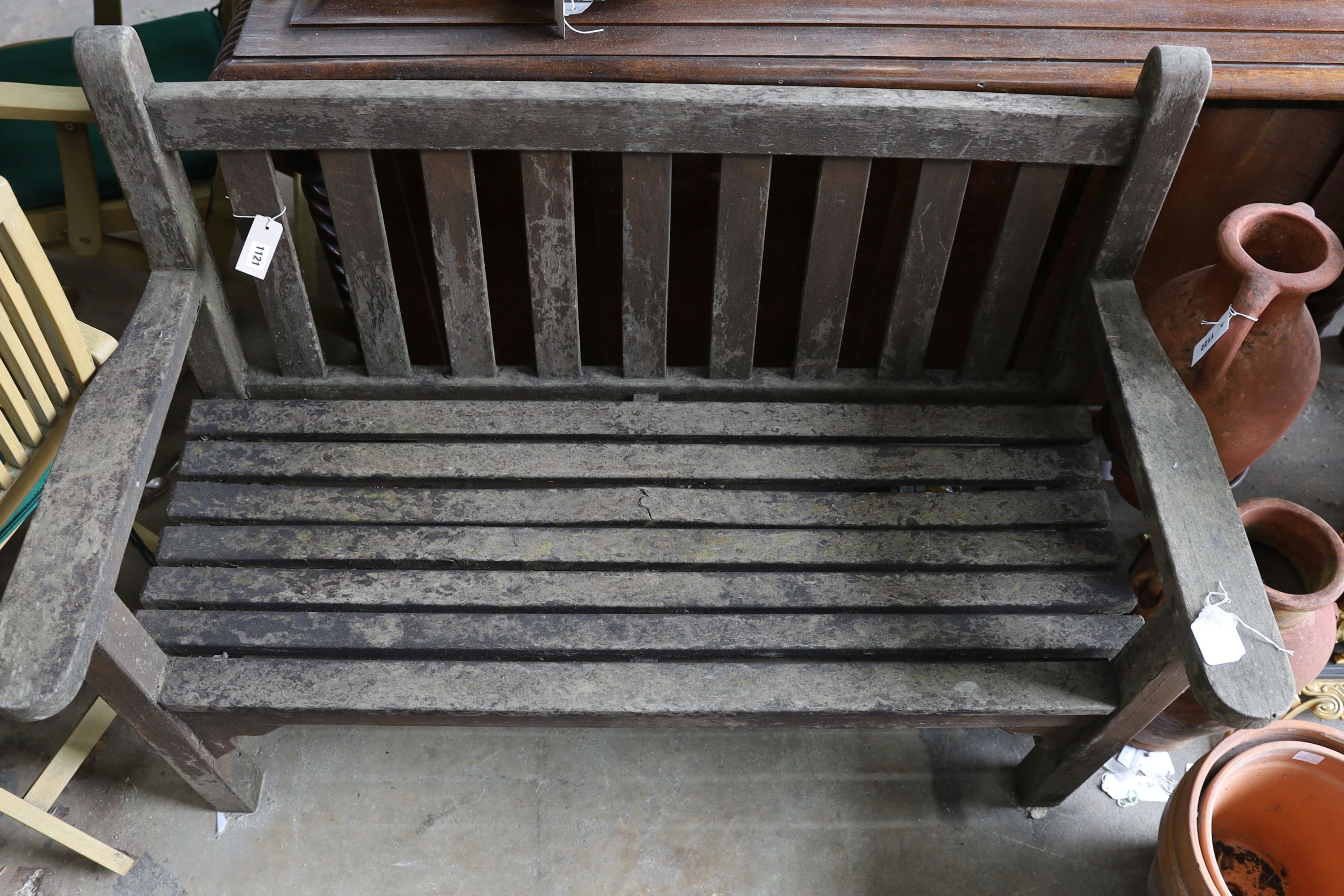 A weathered teak slatted garden bench, length 128cm, depth 62cm, height 91cm